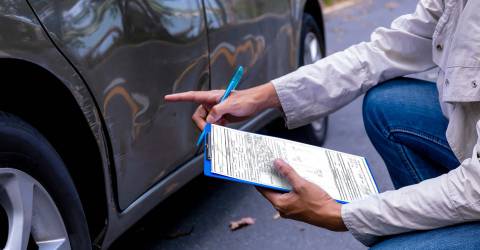 Schade expert bekijkt de schade aan een auto