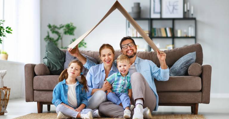 Gezin in woonkamer onder kartonnen dak